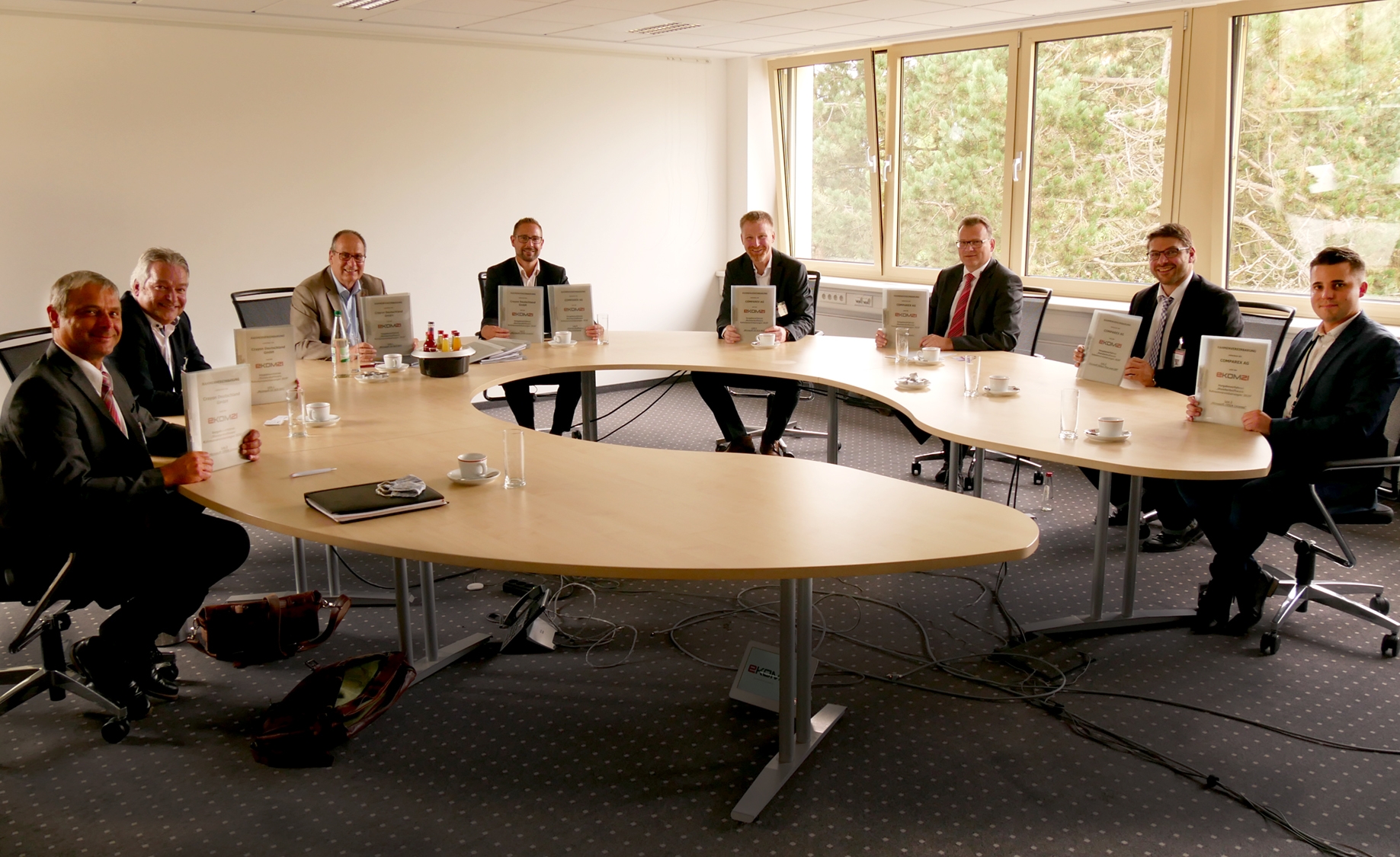 Mitarbeitende der ekom21 und weitere Personen präsentieren Dokumente.