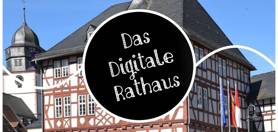 Schriftzug; mit einem Rathausgebäude im Hintergrund.