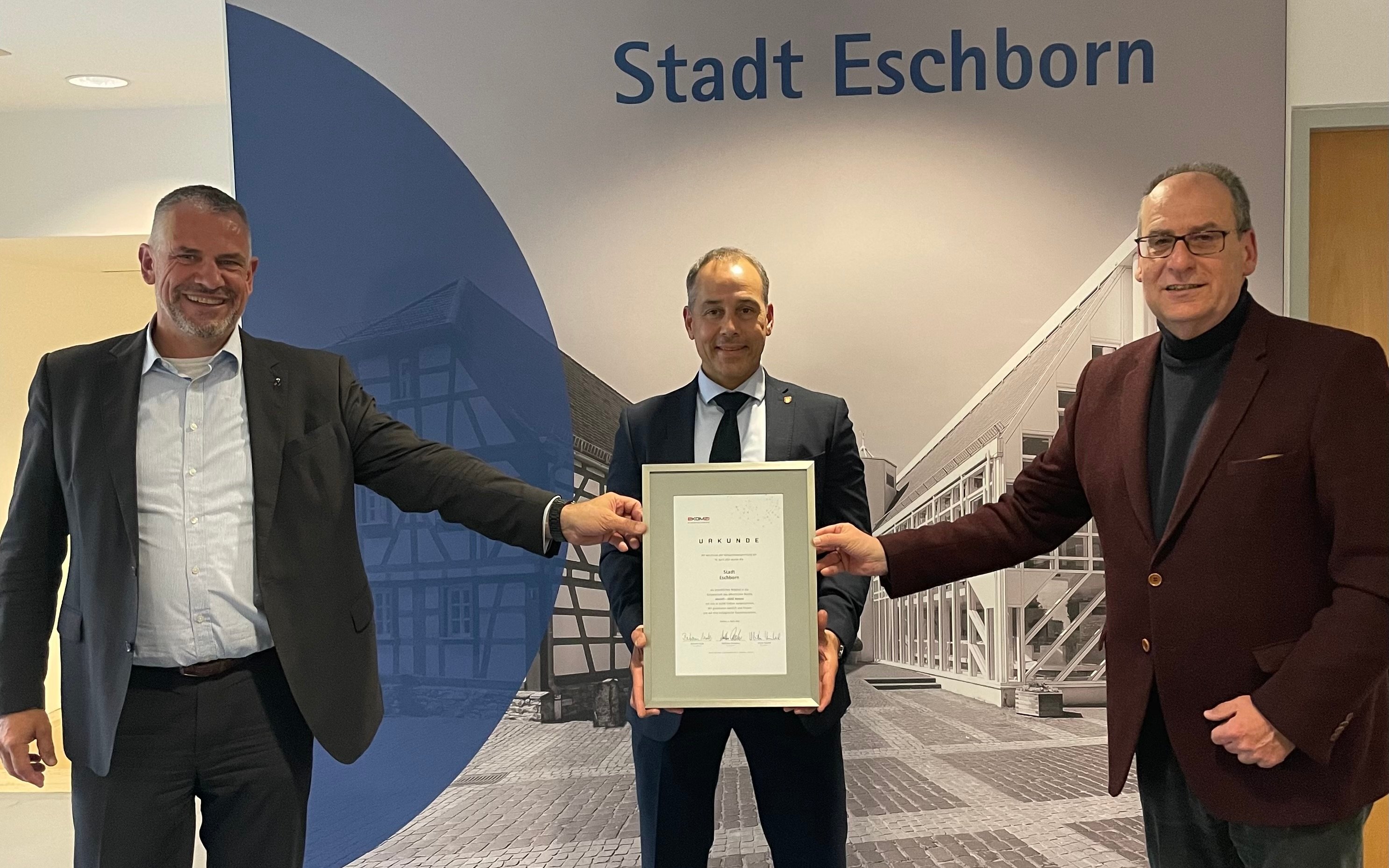 Betram Huke und Matthias Drexelius überreichen Adnan Shaikh eine Urkunde.