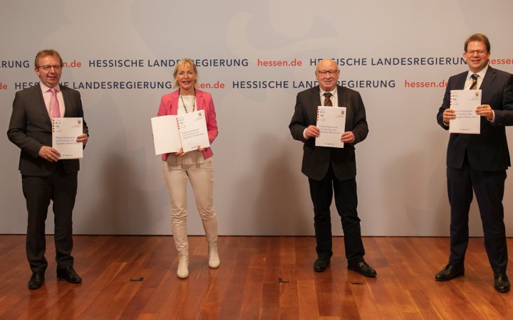 Vier Personen; welche Urkunden präsentieren.