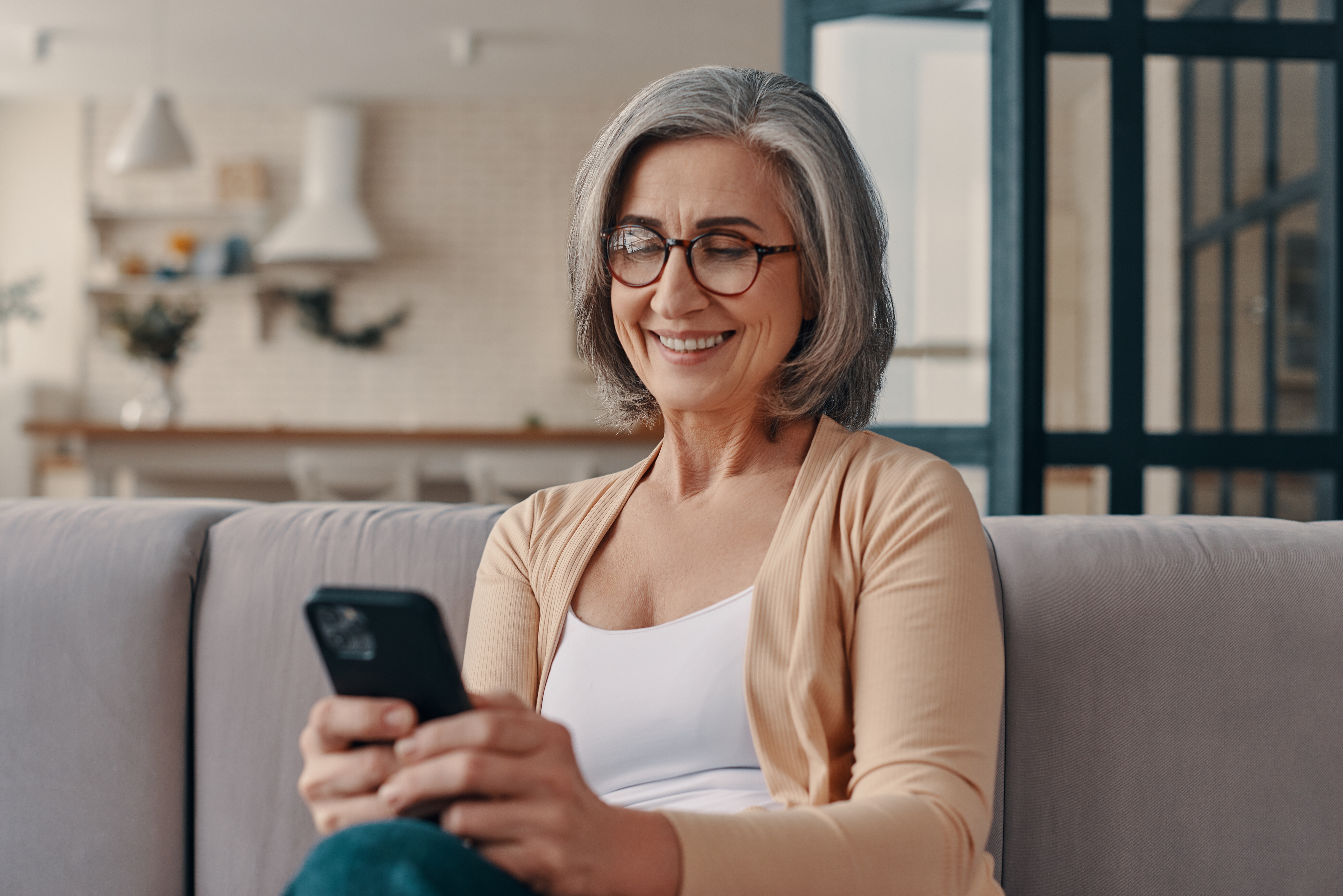 Beautiful senior woman in casual clothing Frau; die ein Smartphone hält.