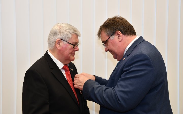 Mark Weinmeister übergibt das Bundesverdienstkreuz an Harald Plünnecke.