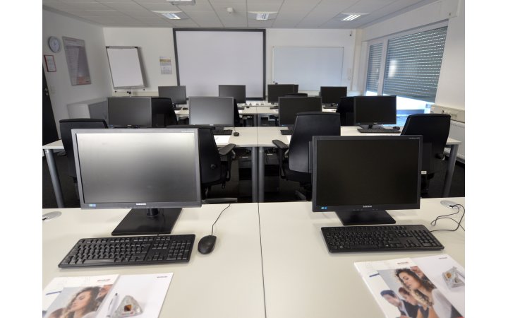 Seminarraum mit mehreren Arbeitsplätzen mit Computern, Maus und Tastatur