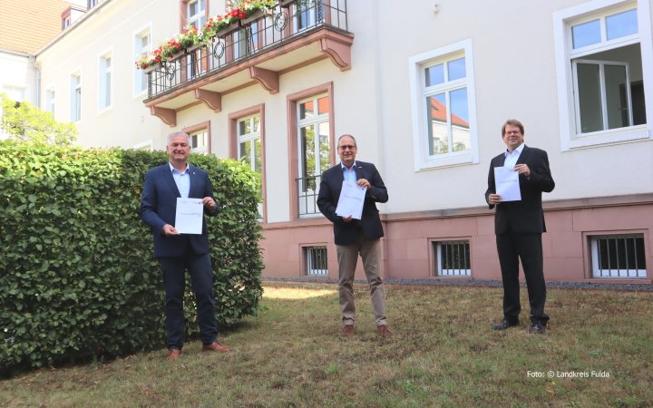 Bernd Woide; Bertram Huke und Heiko Wingenfeld vor der Aussenfassade eines Gebäudes.