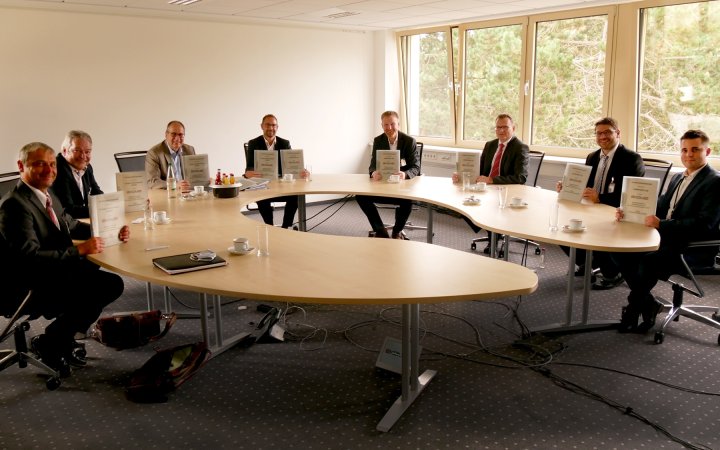 Mitarbeitende der ekom21 und weitere Personen präsentieren Dokumente.