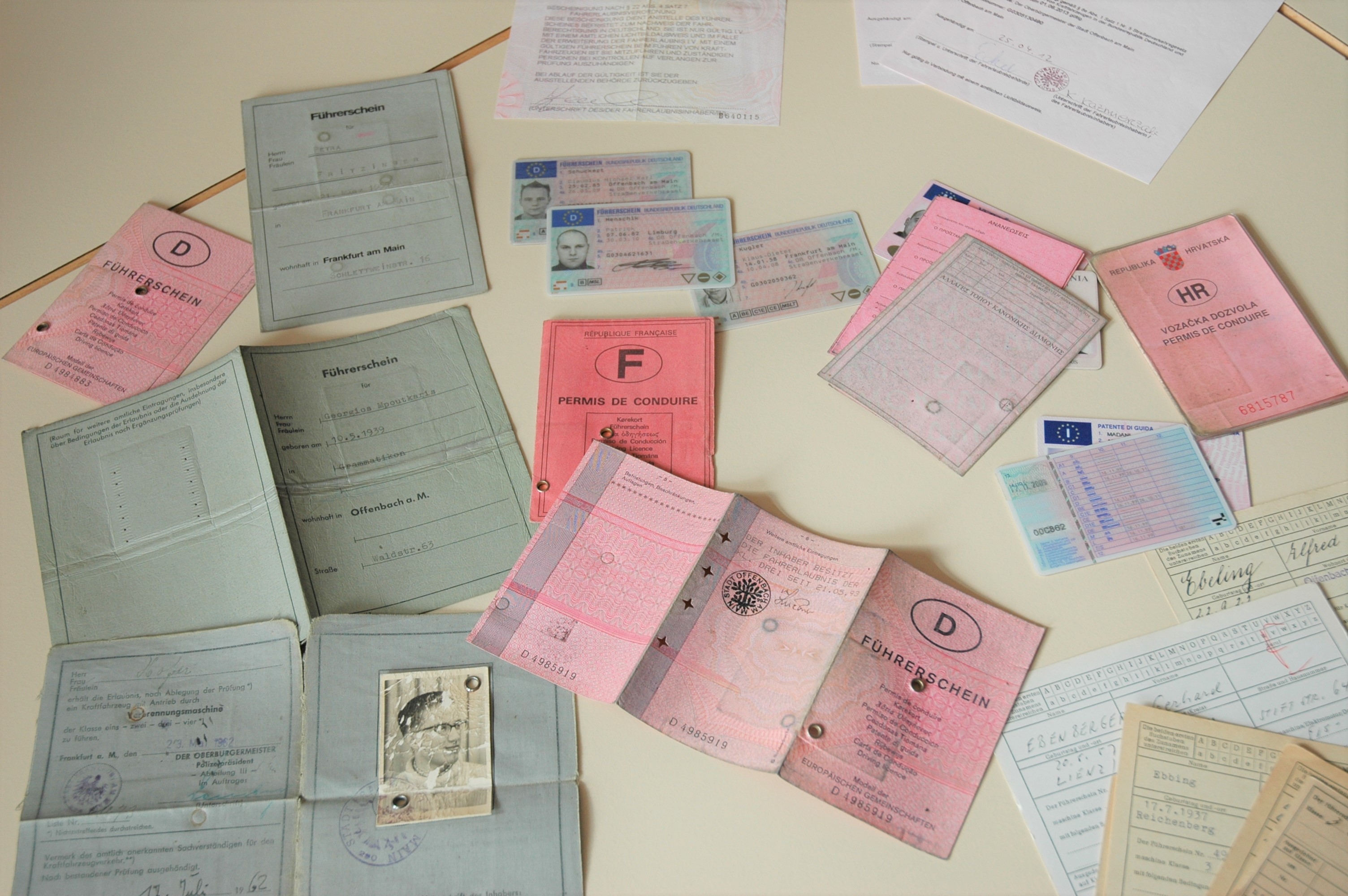 Mehrere Führerscheine verschiedener Art liegen auf einem Tisch.