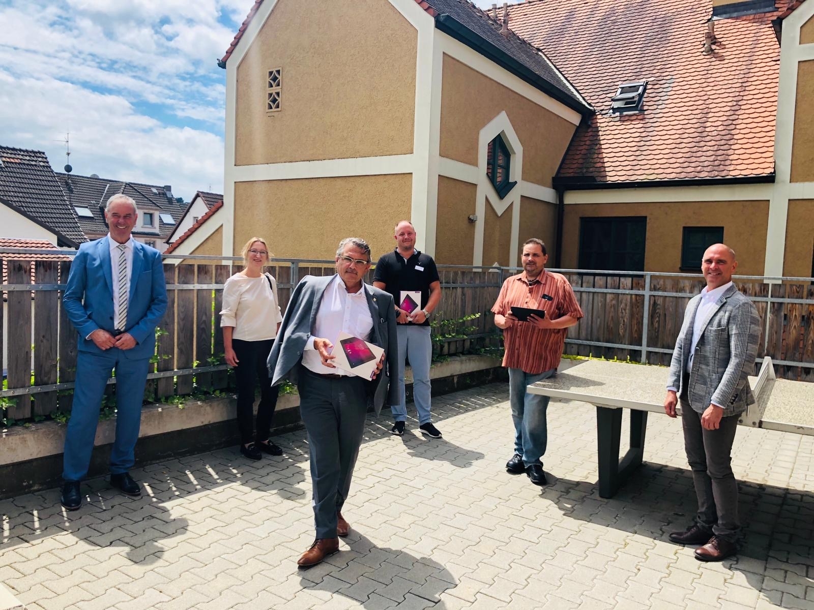 Gruppe von sechs Personen präsentieren Tablets.