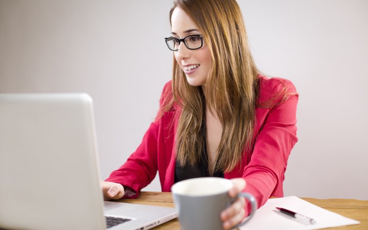 Frau sitzend vor einem Laptop.