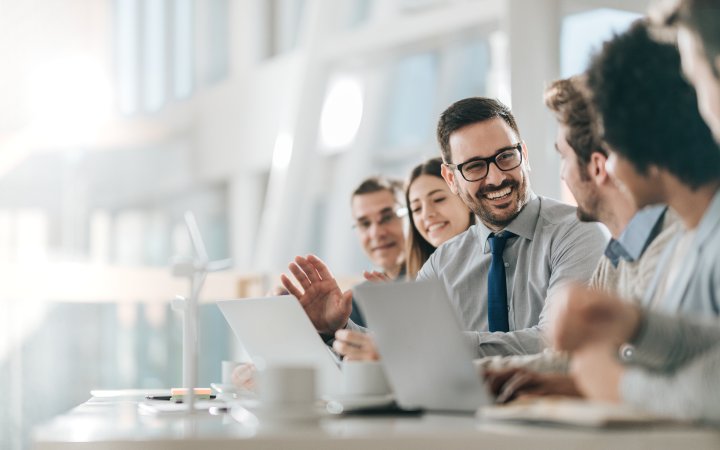 Happy businessman talking to his colleagues on a meeting in the office,