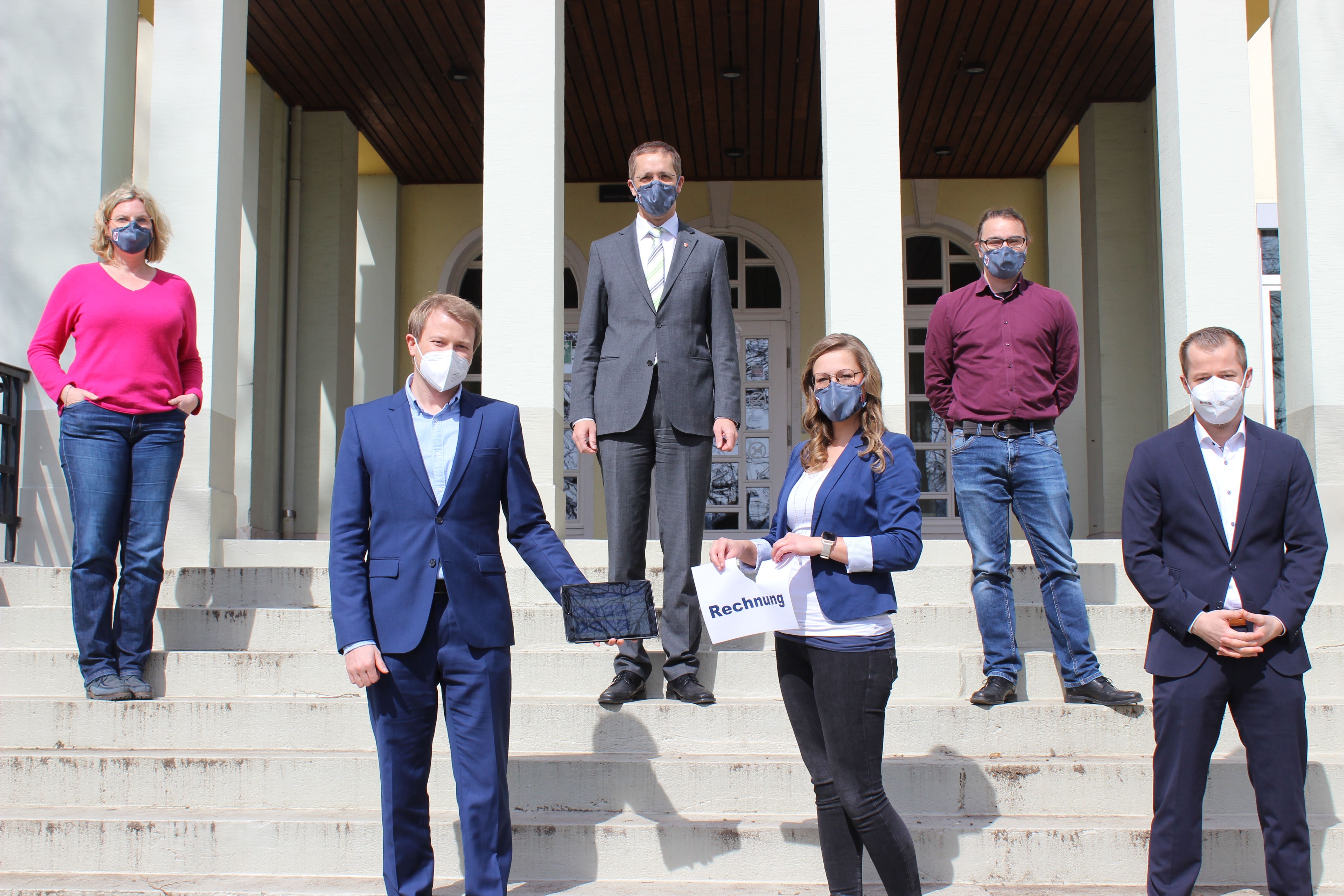 Gruppe von sechs Personen auf der Treppe eines Gebäudes.