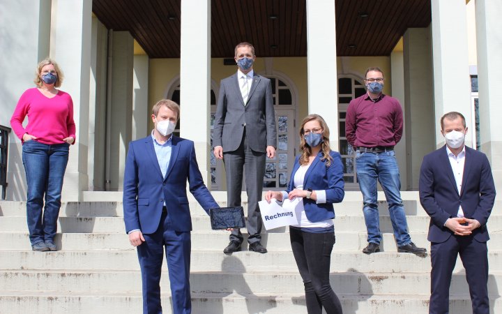 Gruppe von sechs Personen auf der Treppe eines Gebäudes.