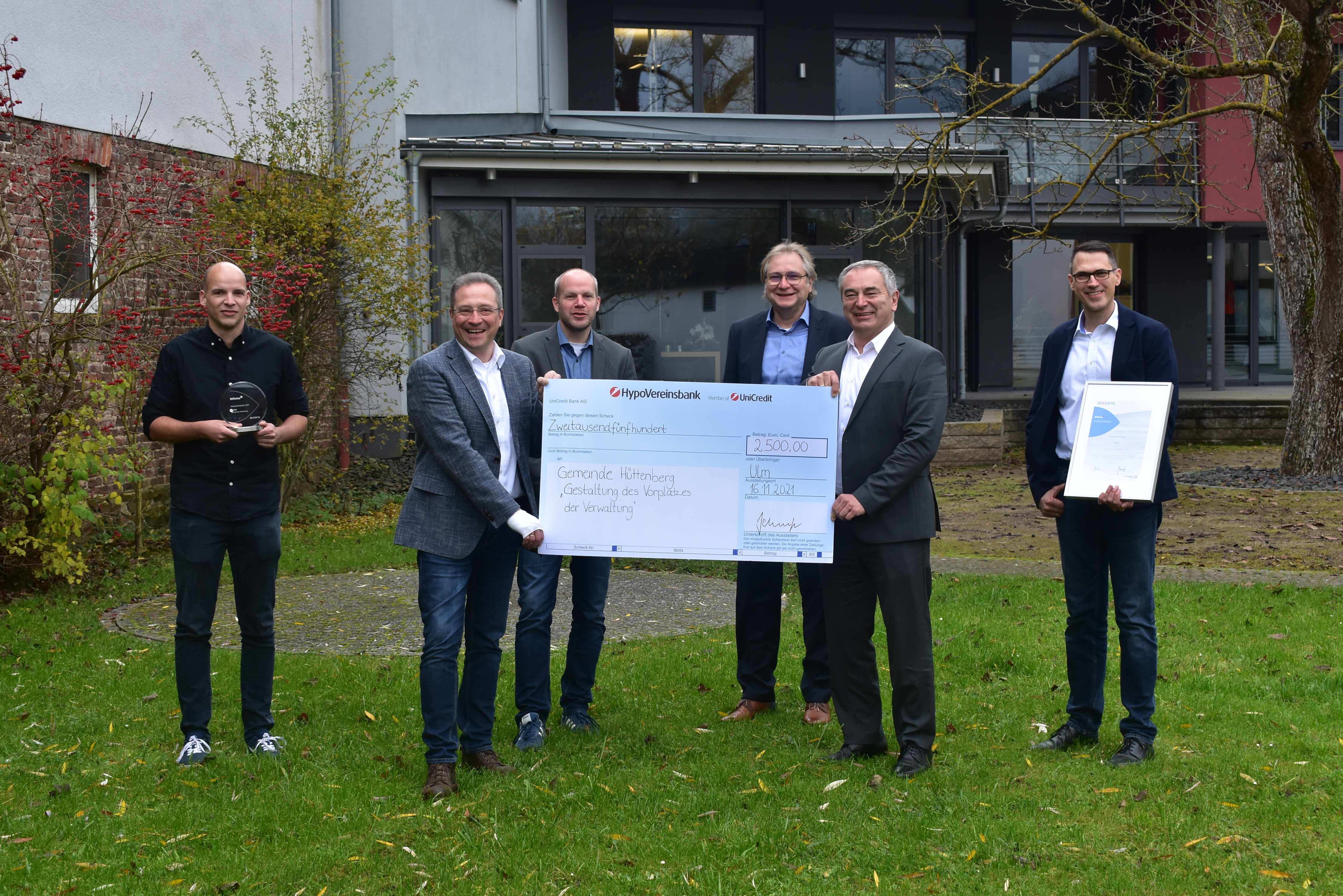 Gruppe von acht Personen während der Präsentation eines Preises.