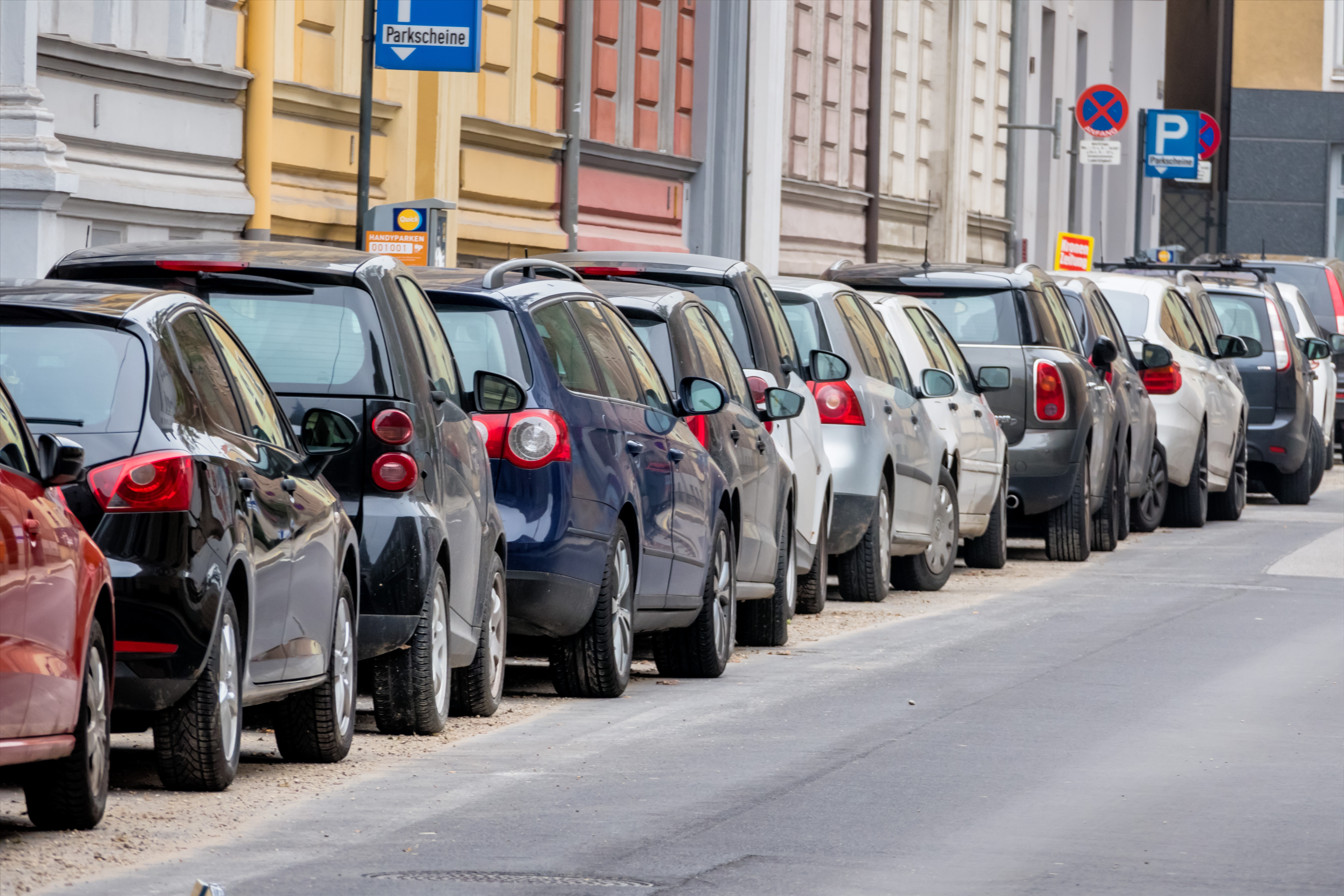 Reihe von mehreren parkenden Autos am Straßenrand.