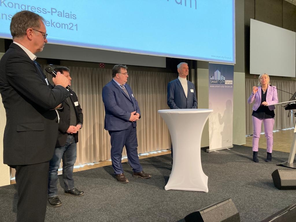 Mehrere; sich unterhaltende Personen während einer Podiumsdiskussion.