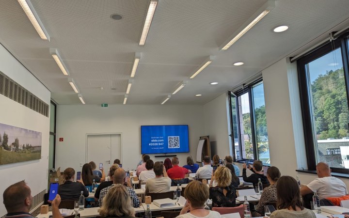 Teilnehmende während einer Präsentation des Umfrageprogramms Slido.