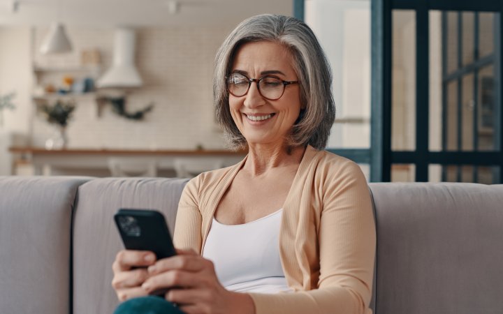 Frau; die ein Smartphone hält.