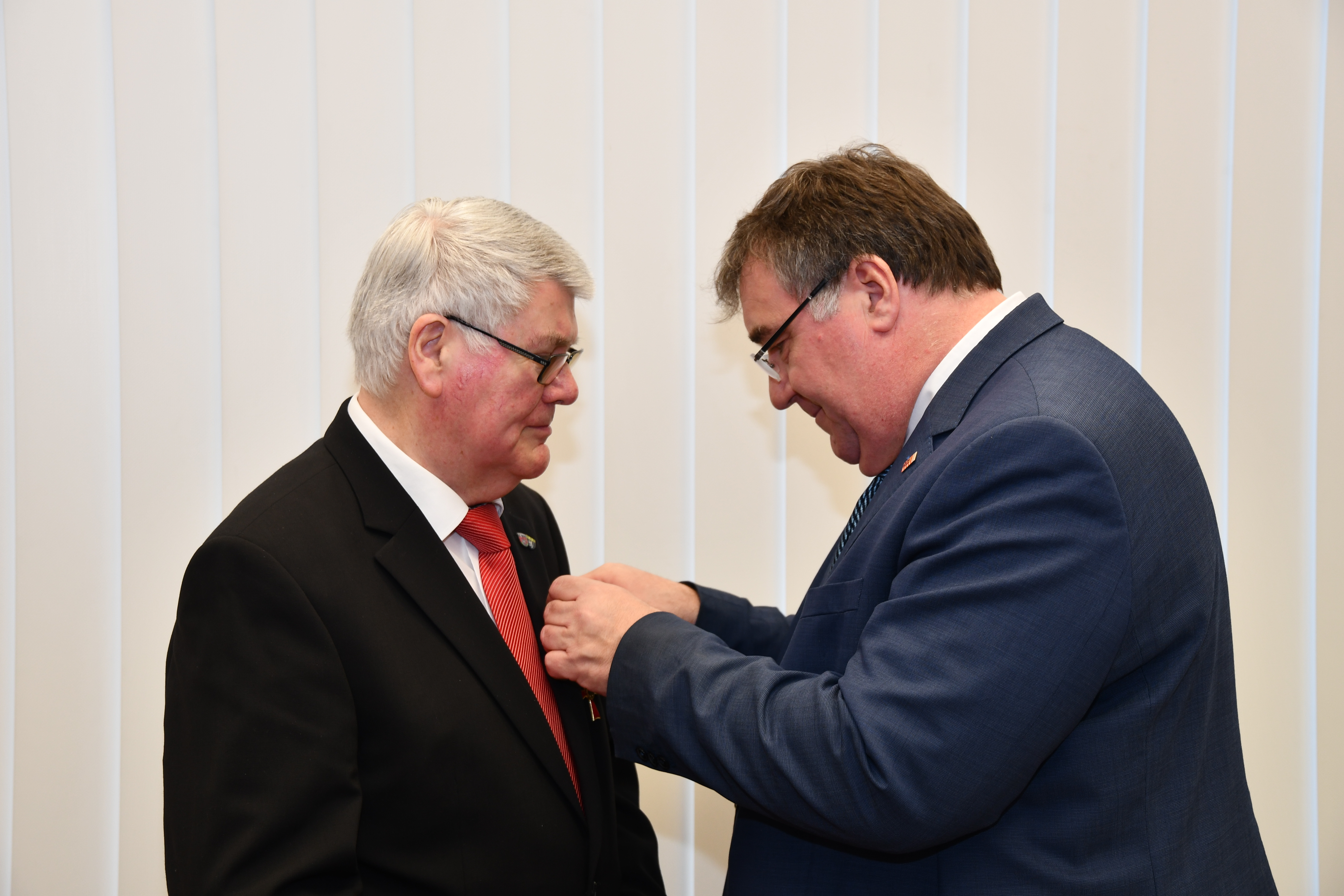 Mark Weinmeister übergibt das Bundesverdienstkreuz an Harald Plünnecke.
