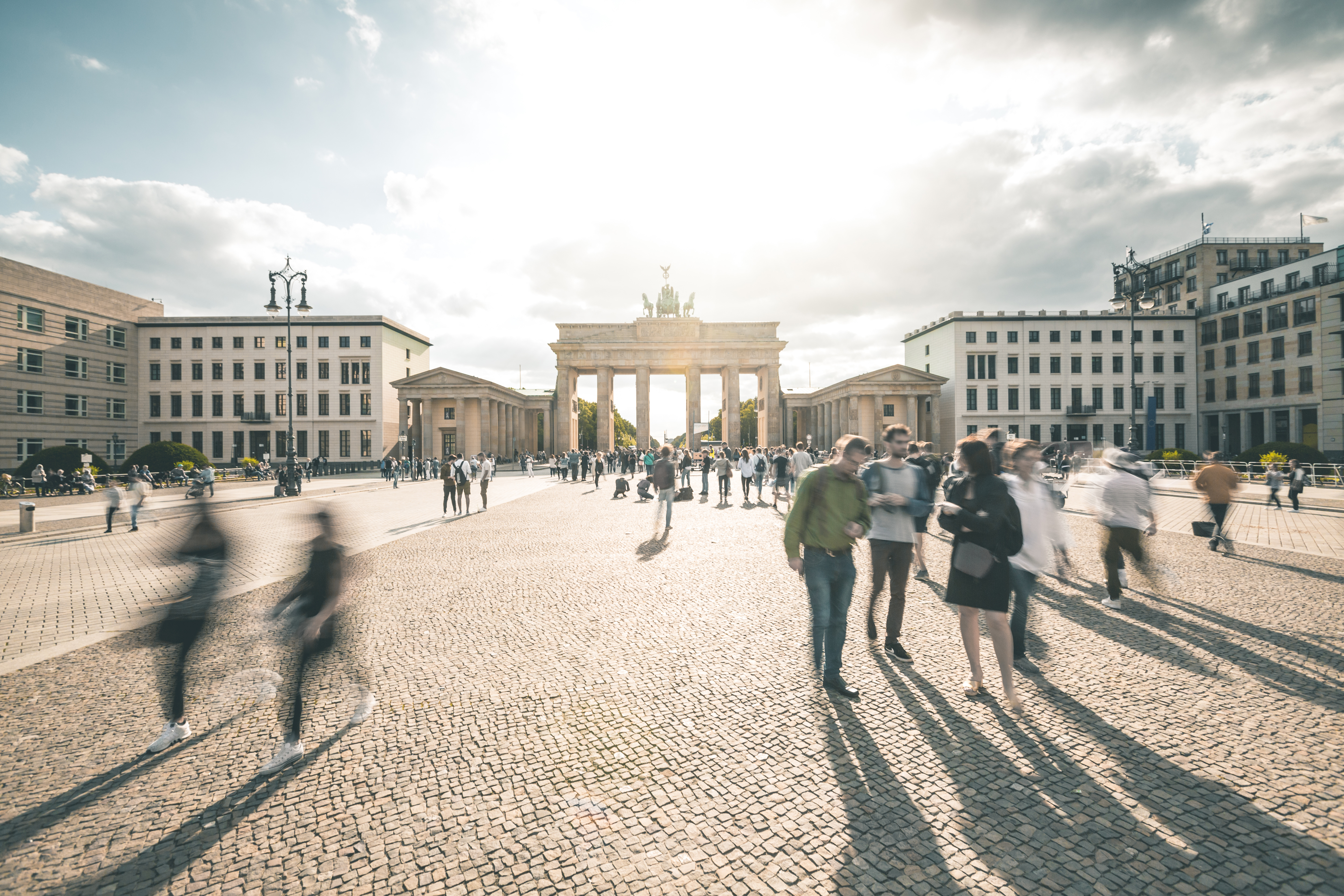 Das Brandenburger Tor in Berlin mitsamt Umgebung und Passanten.
