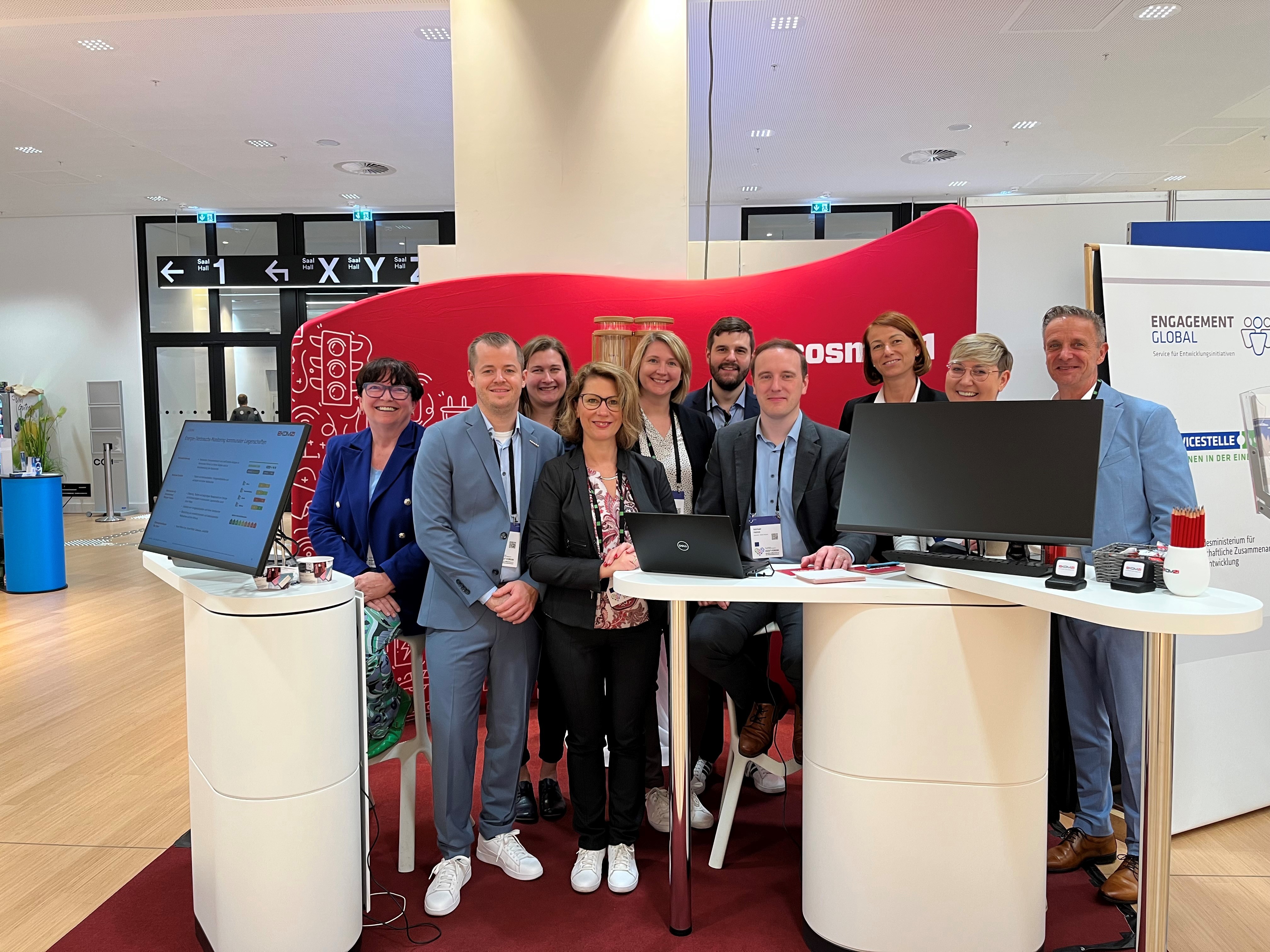 ekom21-Mitarbeitende und Besucher des KGST-Forums an einem Stand der ekom21.