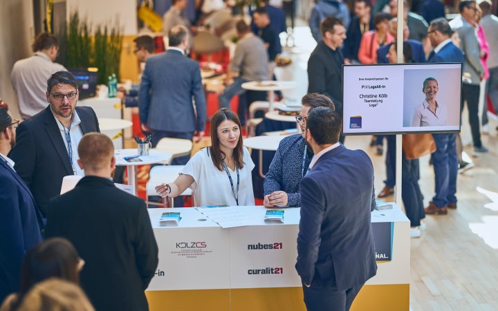 Stand der expo 2024 mit mehreren miteinander sprechenden Personen.