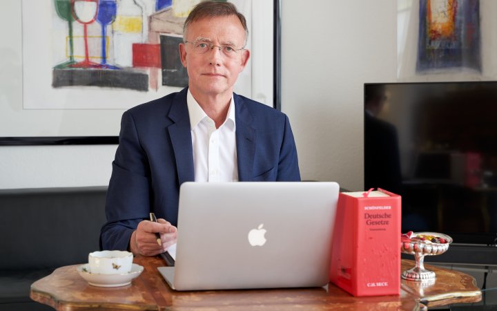 Gerd Landsberg sitzend vor einem Tisch mit Laptop.