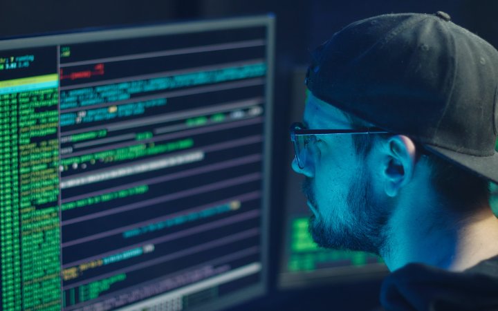 Mann sitzend vor einem Bildschirm.