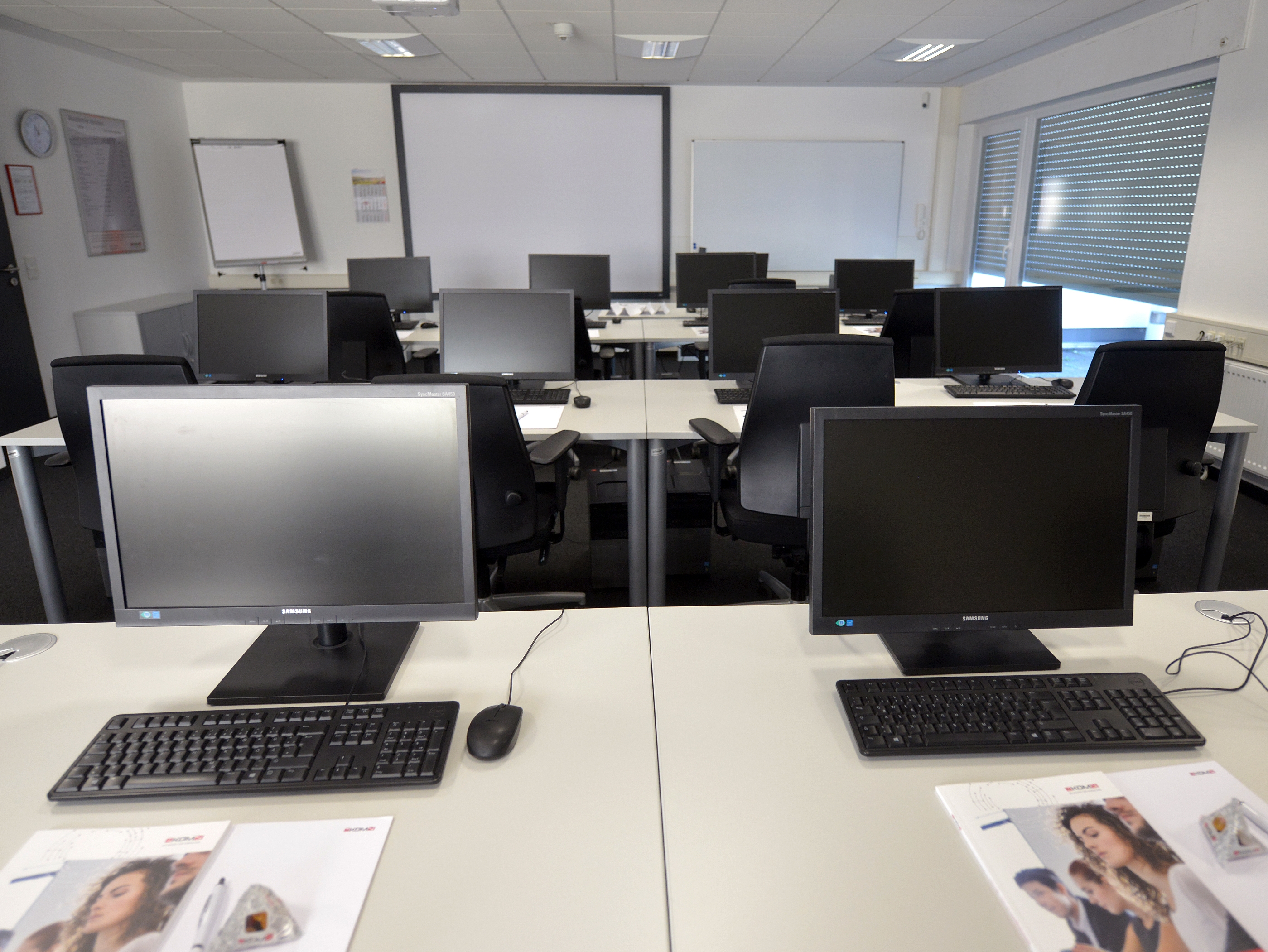 Seminarraum mit mehreren Arbeitsplätzen mit Computern, Maus und Tastatur