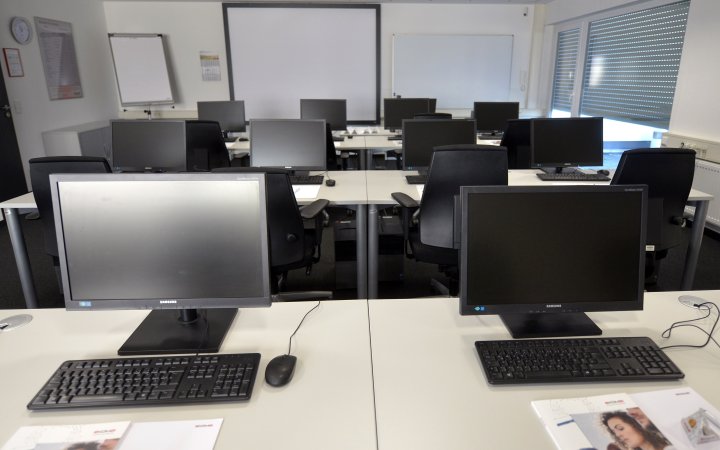 Seminarraum mit mehreren Arbeitsplätzen mit Computern, Maus und Tastatur